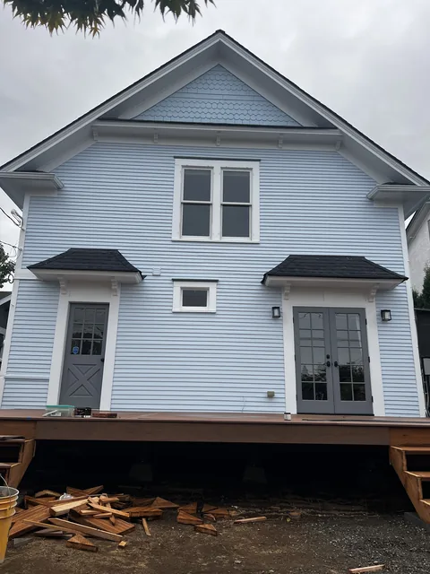 Rear elevation of a restored 1909 Broadway Park home in Bellingham with repaired and repainted siding and trim hoods.