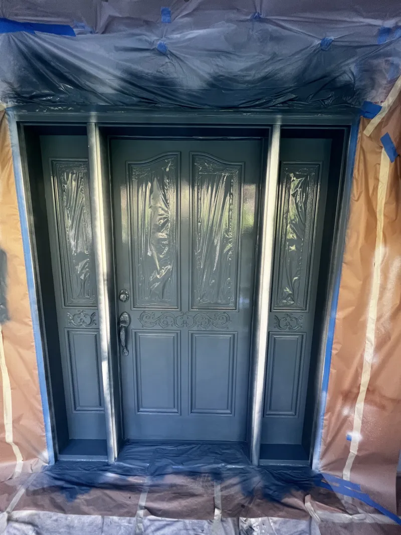 Freshly sprayed Waterloo blue front door with the glass and surroundings still masked