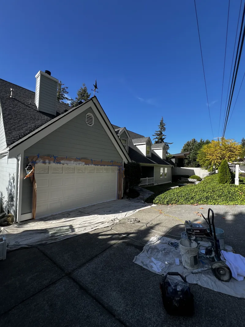Garage door masked and prepped with the paint sprayer set up on a protected driveway on Chuckanut Drive