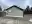 Side gable of the Eldridge home with decades of failed paint scraped away, exposing bare cedar lap siding before priming, Bellingham, WA.