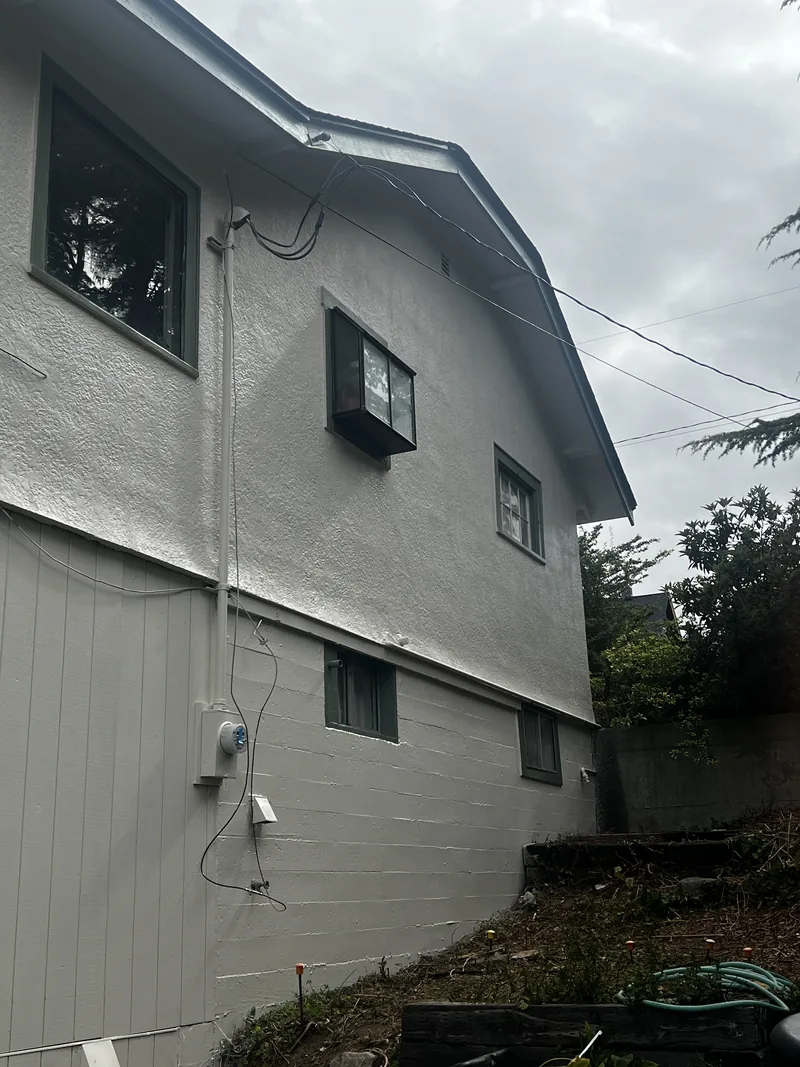 The same Fairhaven stucco wall after patching and elastomeric coating—cracks bridged and the surface reading as one uniform texture.